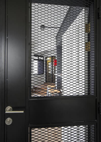 This gate has an oblong panel that is positioned in the middle of the expanded metal mesh door.