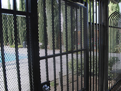 This is a perimeter fence with posts and expanded metal gate protected, painted all black.