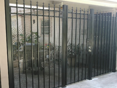 Black painted gate reinforced with many vertical posts to prevent deformation.