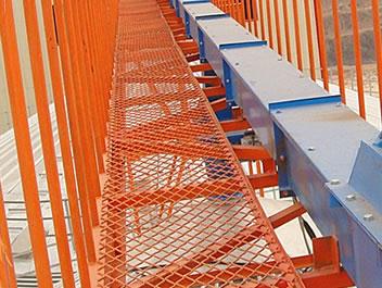 The picture shows one orange expanded metal grating at a construction site, with railings at two sides.